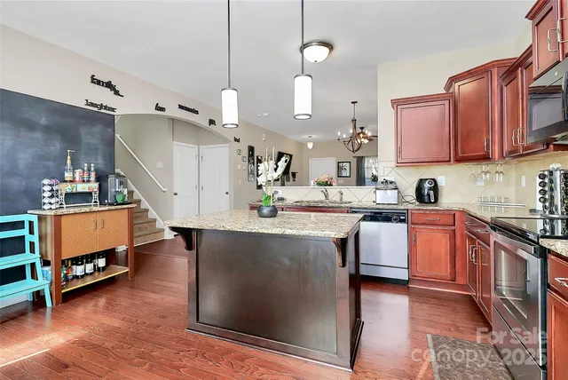 a kitchen with granite countertop a sink a counter space appliances and cabinets