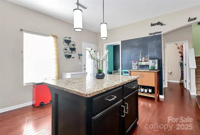 a kitchen with a counter space appliances and wooden floor