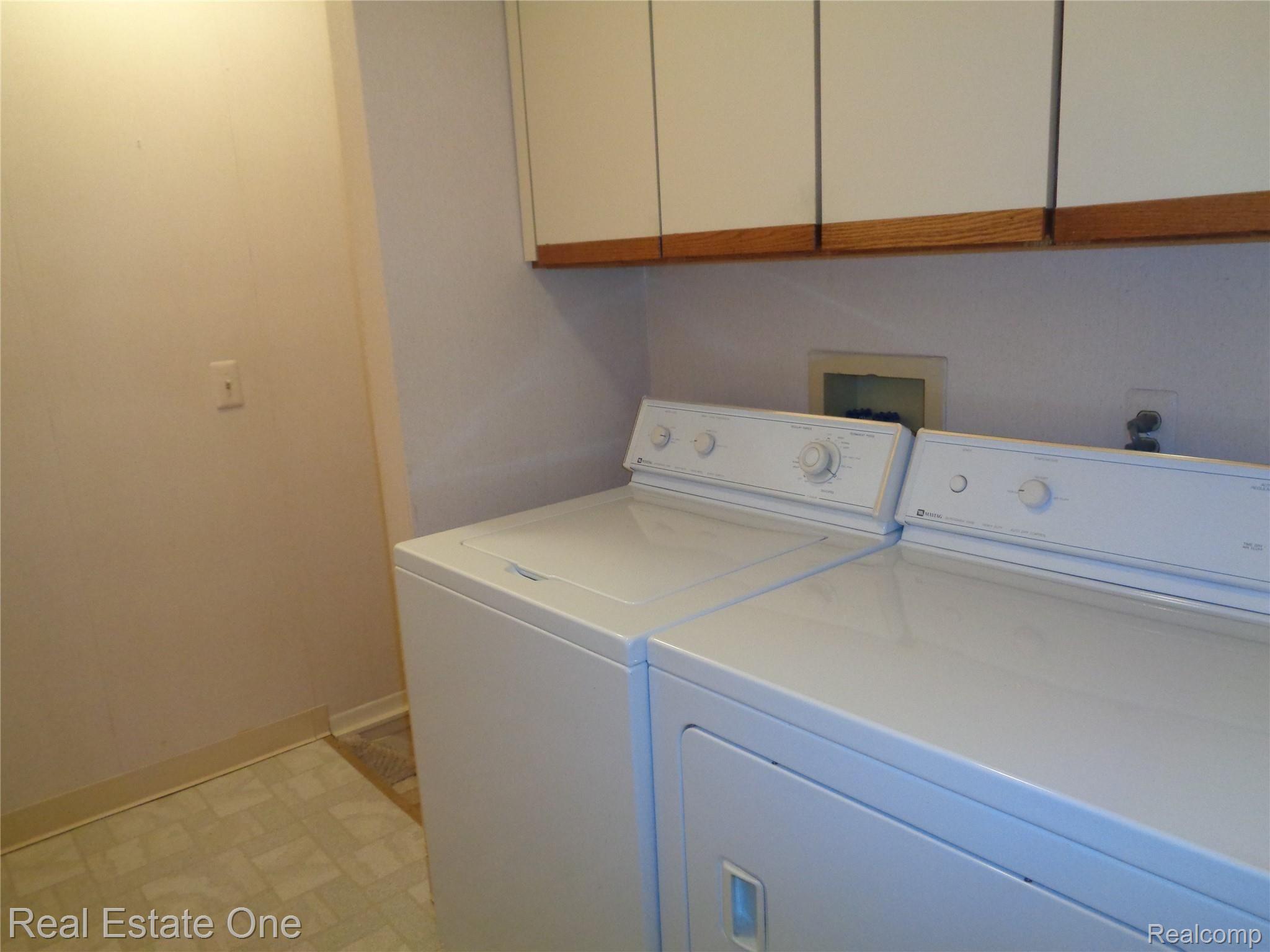 624 Tennyson, Unit 113 Rochester, MI 48307 - Photo 20 of 51 Entry level laundry room with extra cabinetry, washer and dryer INcluded in sale.