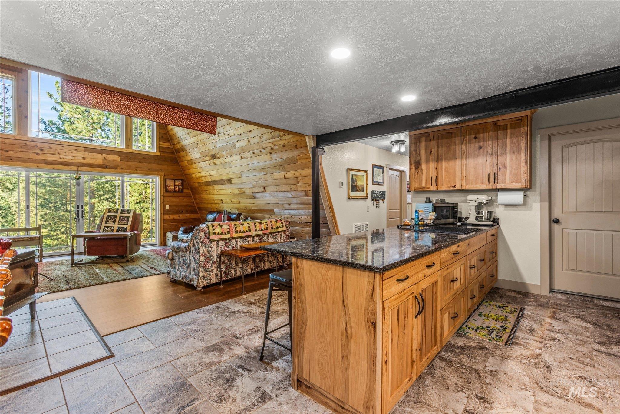 1 Sunset Trail Banks, ID 83602 - Photo 11 of 42 Open-concept living space featuring a wood-paneled accent wall and large sliding glass doors