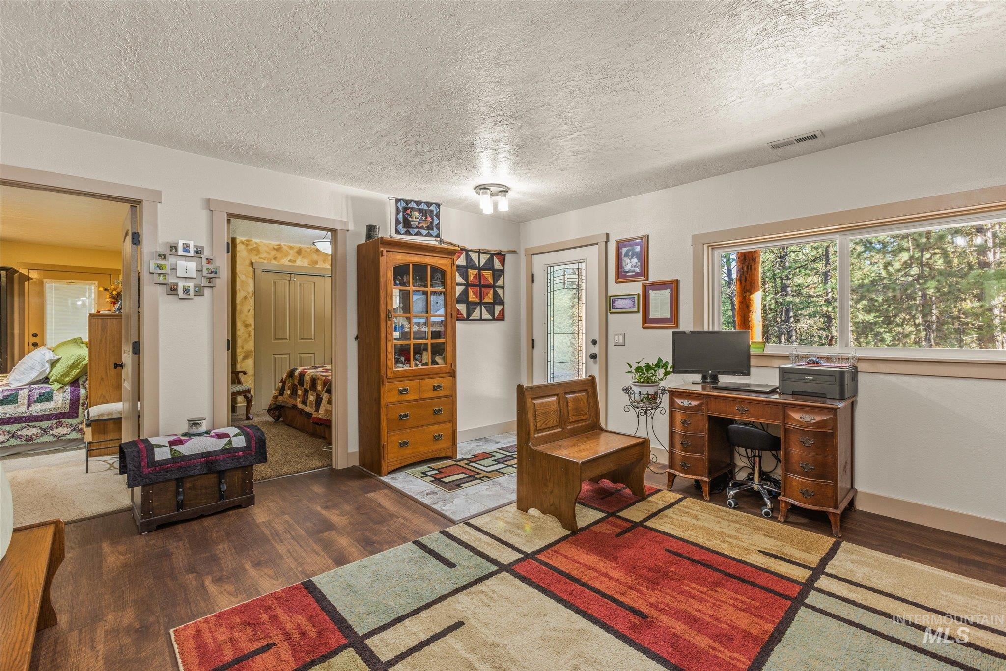 1 Sunset Trail Banks, ID 83602 - Photo 16 of 42 Room featuring wood-finish flooring, white walls, and a large window overlooking a wooded exterior
