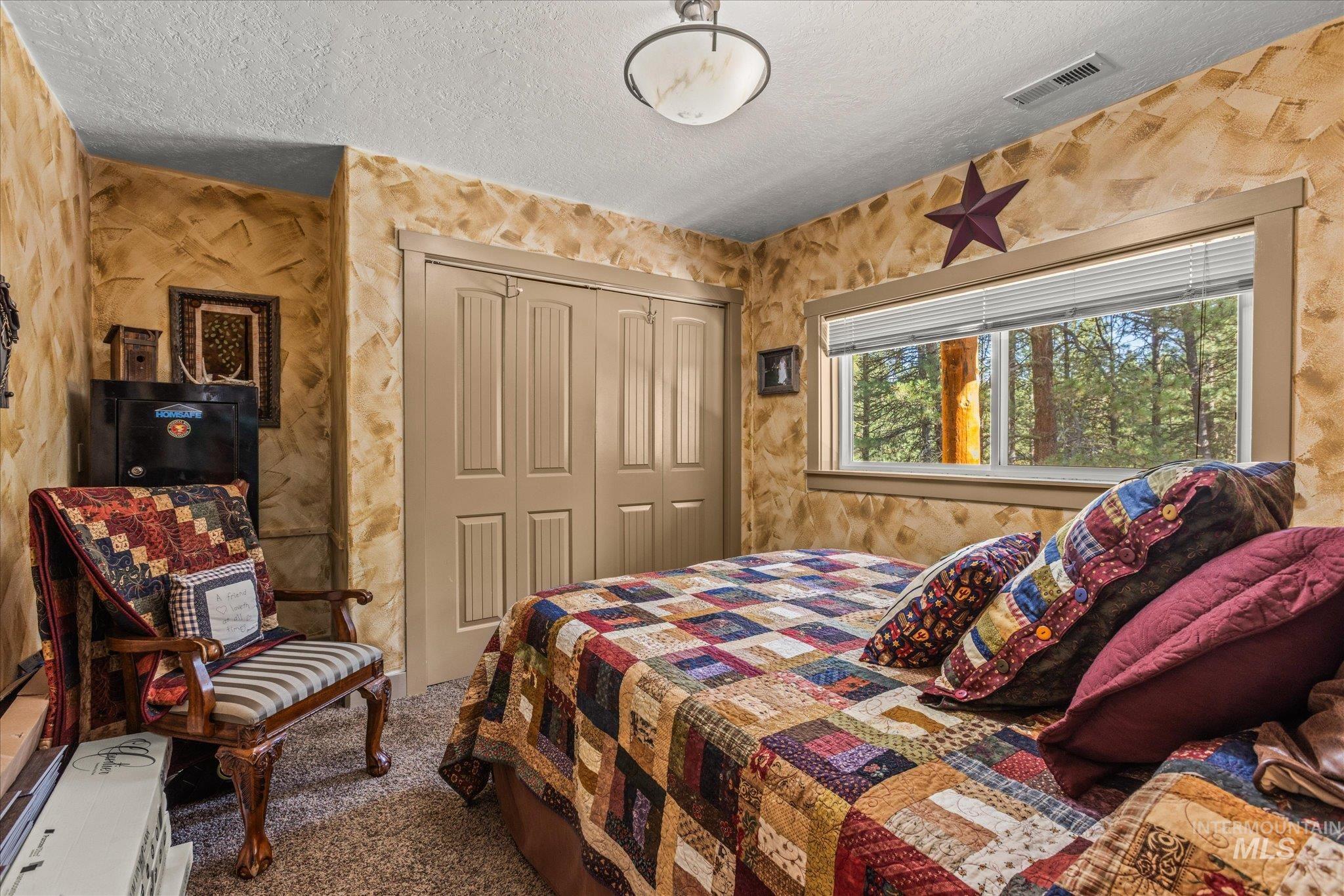 1 Sunset Trail Banks, ID 83602 - Photo 19 of 42 Carpeted room featuring a large window with horizontal blinds, providing a wooded outdoor scenery
