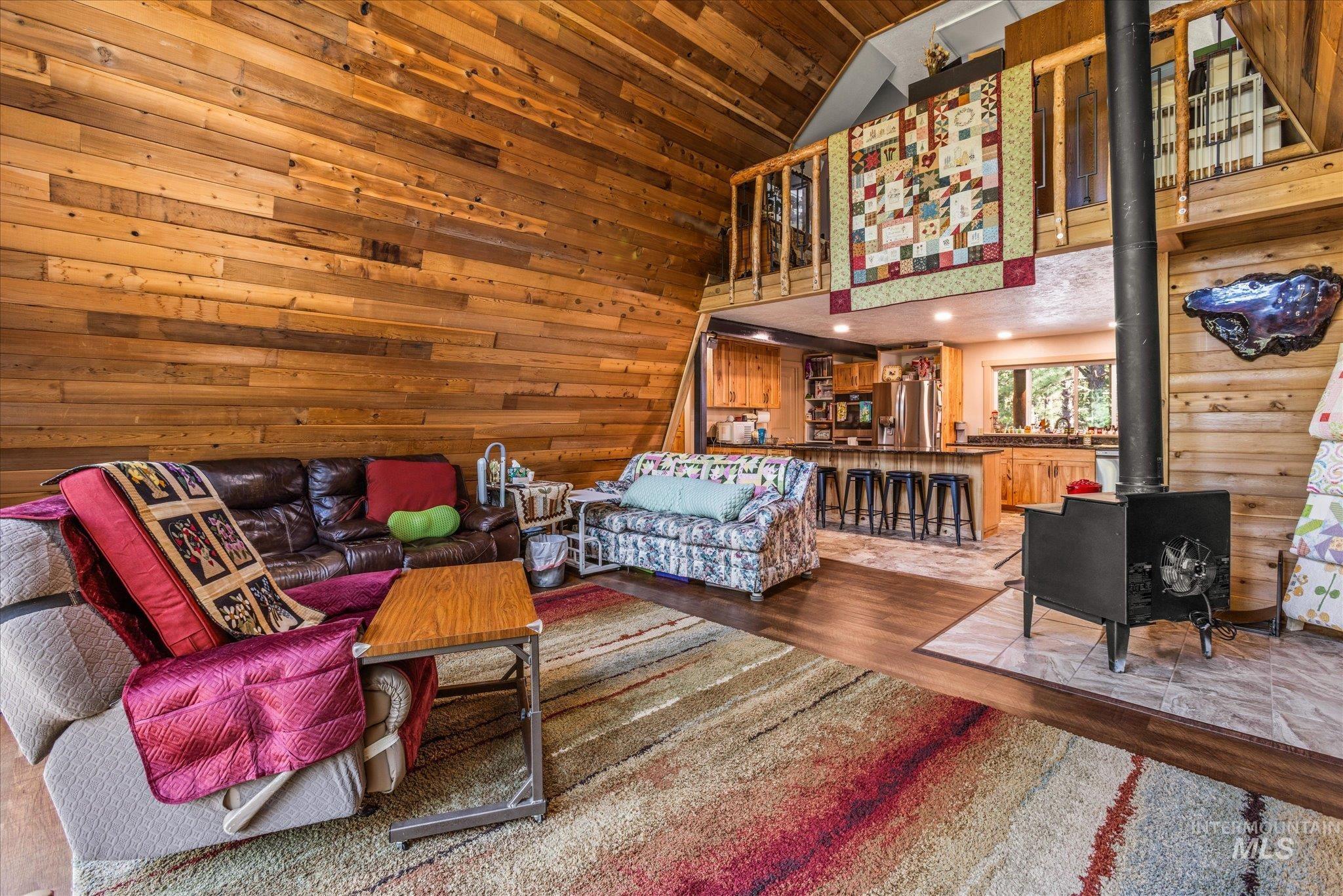 1 Sunset Trail Banks, ID 83602 - Photo 2 of 42 Expansive living area featuring wood-paneled walls and a vaulted ceiling
