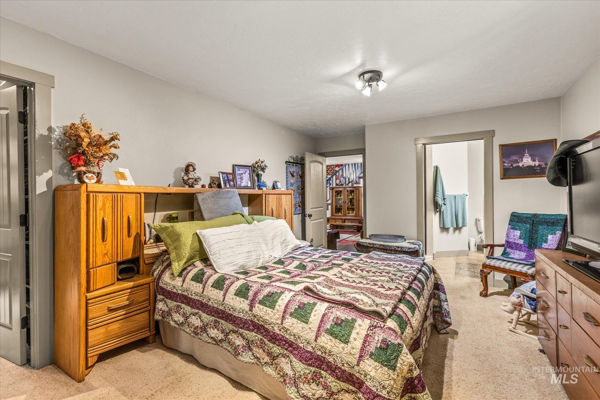 1 Sunset Trail Banks, ID 83602 - Photo 22 of 42 Carpeted bedroom featuring light gray walls, a ceiling-mounted light fixture, and an open doorway revealing a hard-surface floor beyond