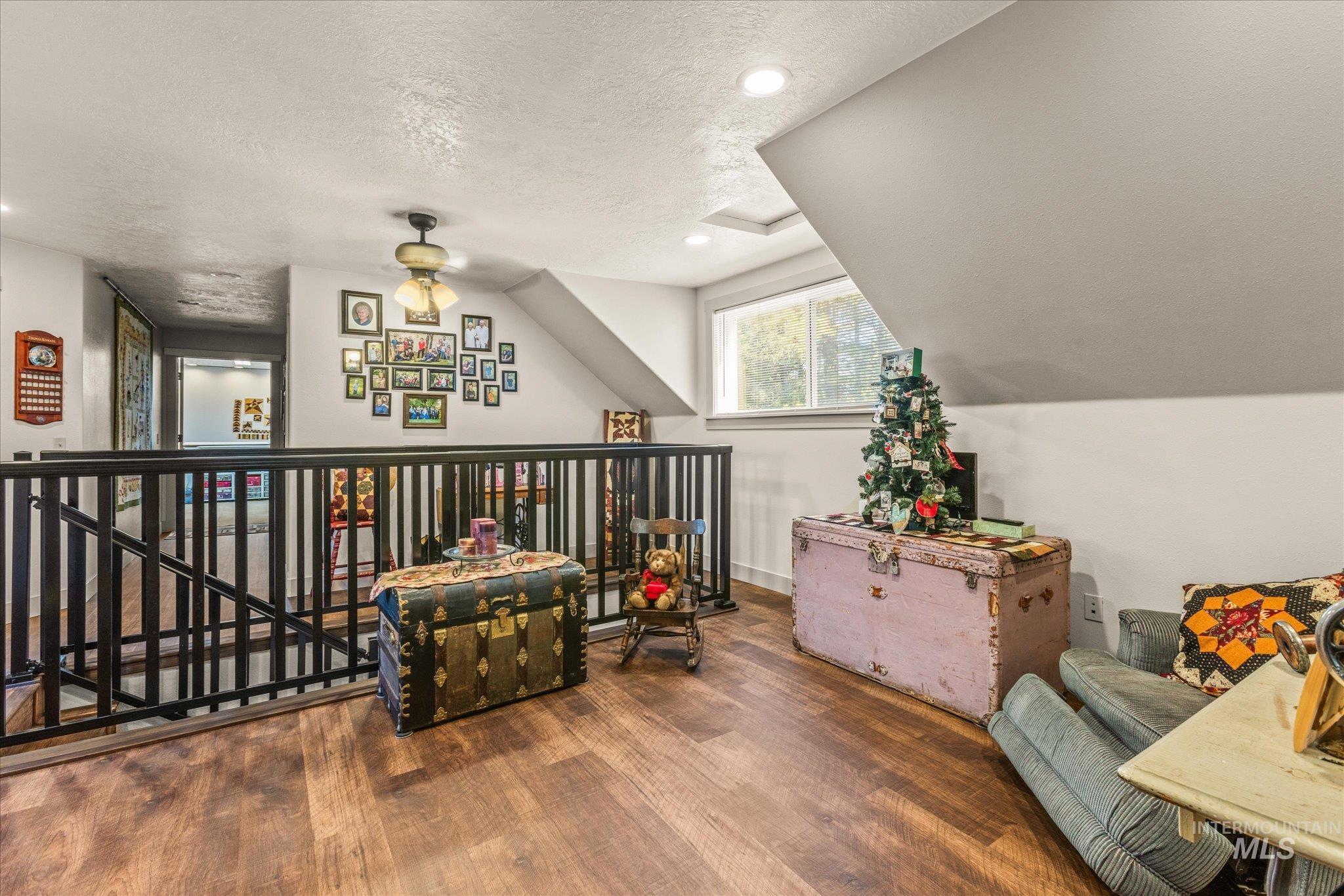 1 Sunset Trail Banks, ID 83602 - Photo 25 of 42 Upper-level loft area with wood-finish flooring, a dark metal spindle railing, and a sloped ceiling