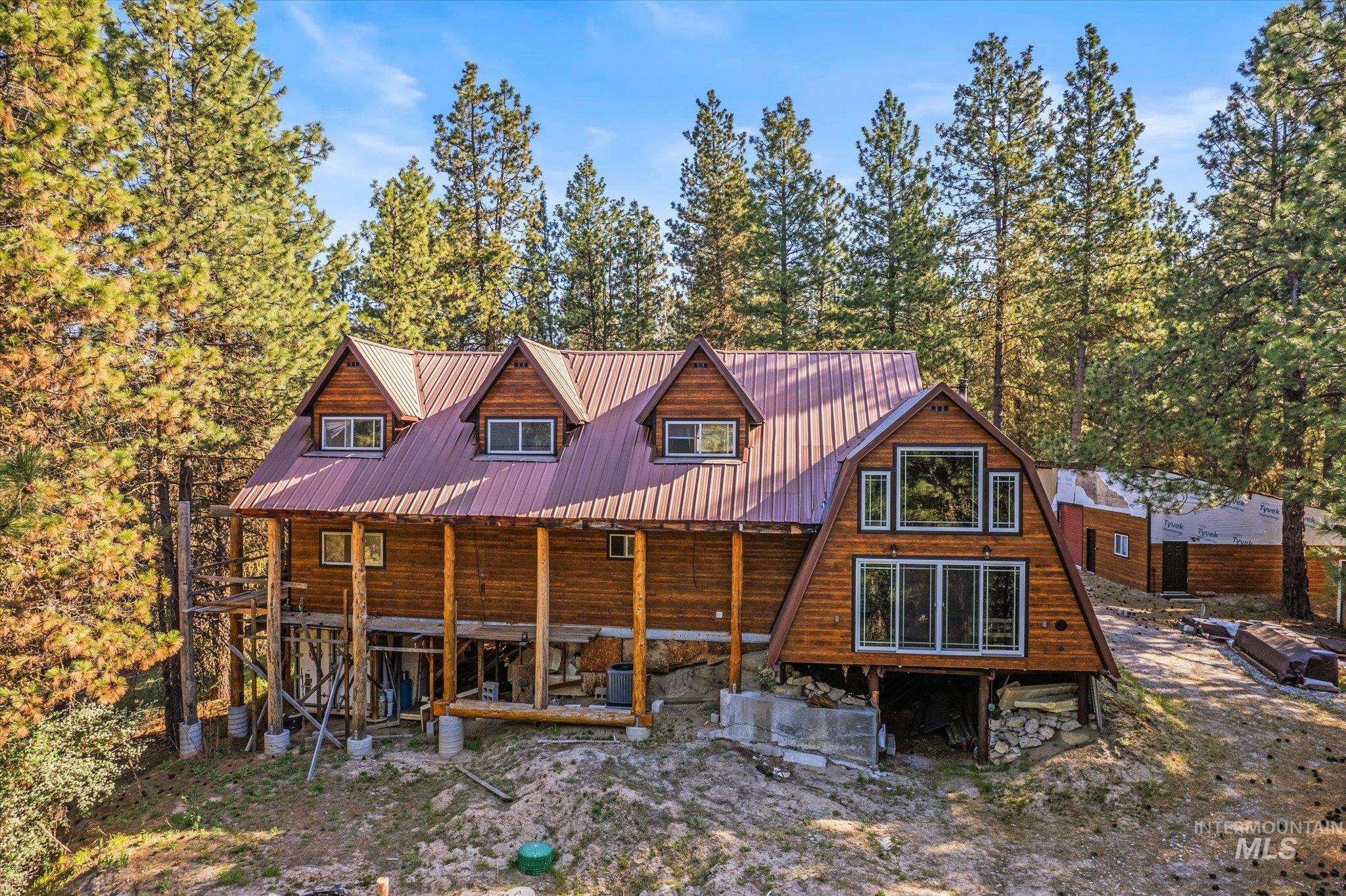 1 Sunset Trail Banks, ID 83602 - Photo 35 of 42 Rustic cabin-style residence featuring a prominent red metal roof, dormer windows, and a wood siding exterior