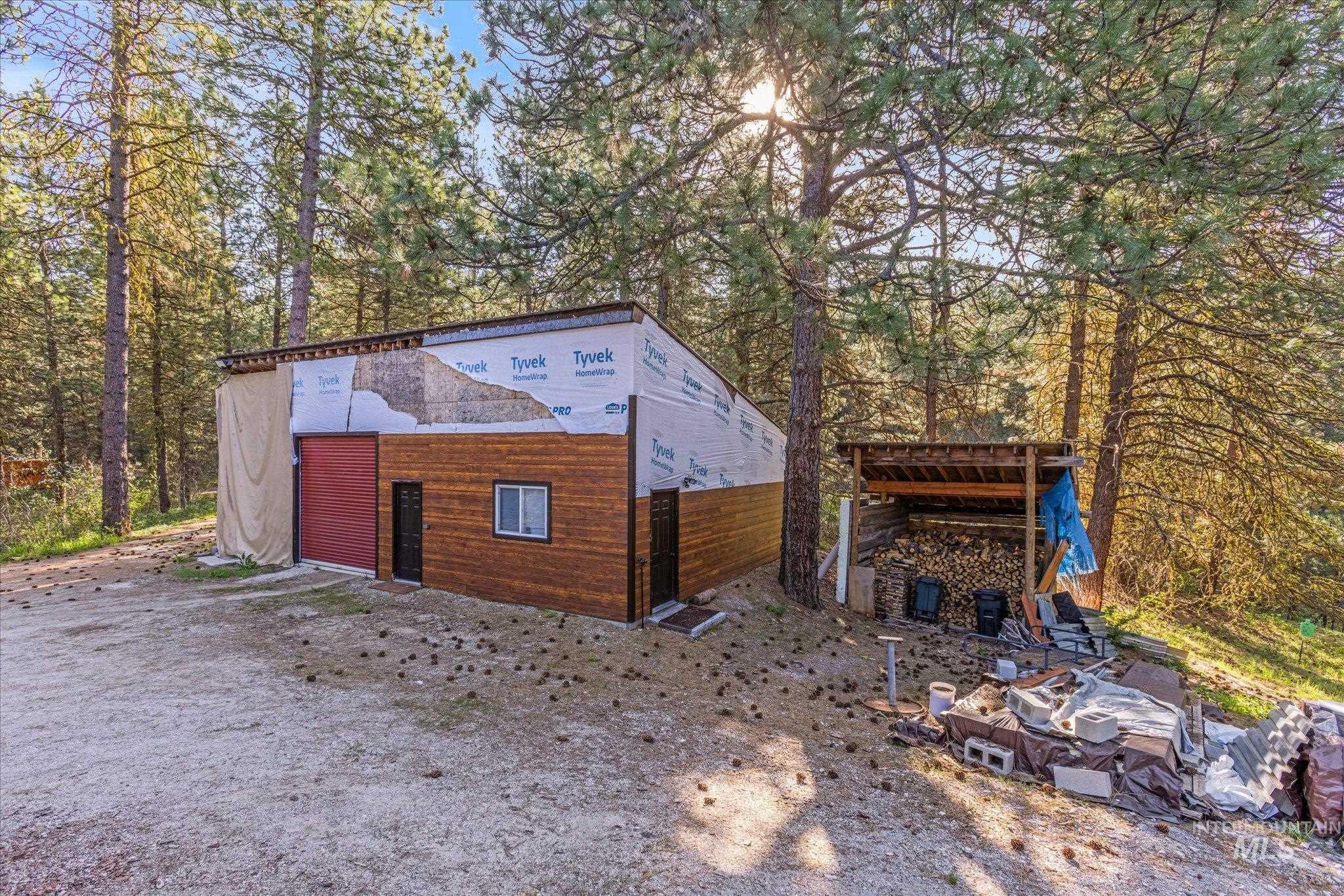 1 Sunset Trail Banks, ID 83602 - Photo 6 of 42 Partially completed structure featuring wood-finish siding, a red garage door, and a single window
