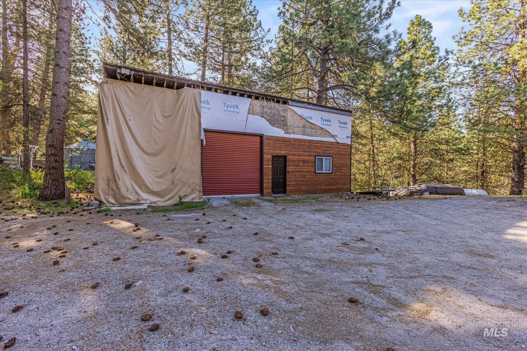 1 Sunset Trail Banks, ID 83602 - Photo 7 of 42 Storage building featuring a red roll-up door, dark entry door, and small window