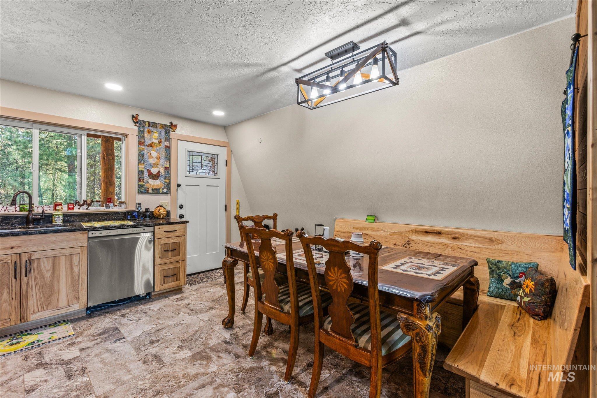 1 Sunset Trail Banks, ID 83602 - Photo 10 of 42 Kitchen and dining area featuring stone-finish flooring, wood cabinetry, and a large window