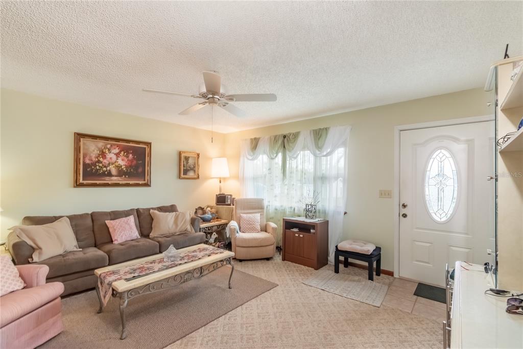 8417 Southwest 106th Street Ocala, FL 34481 - Photo 4 of 49 a living room with furniture a large window and a potted plant