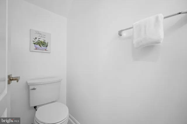 a white toilet sitting next to a white walls