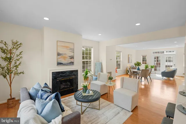a living room with furniture a fireplace a rug and a window