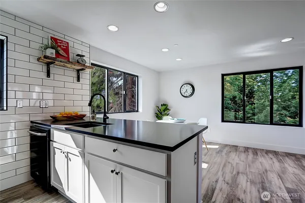 a kitchen with stainless steel appliances granite countertop a stove a sink and a microwave