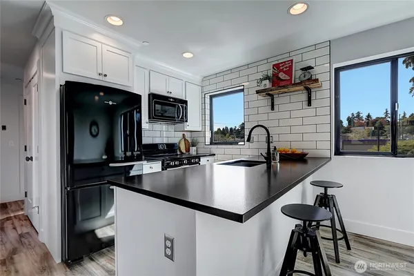 a kitchen with kitchen island a sink appliances and cabinets