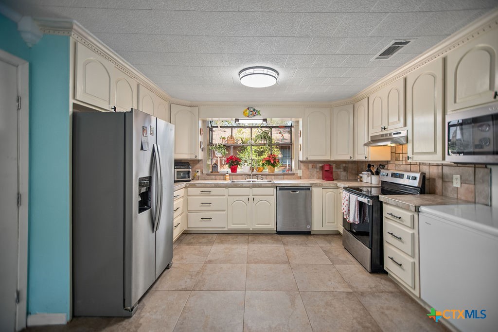 1315 Jackson Street Port Lavaca, TX 77979 - Photo 14 of 32 a kitchen with a refrigerator and cabinets