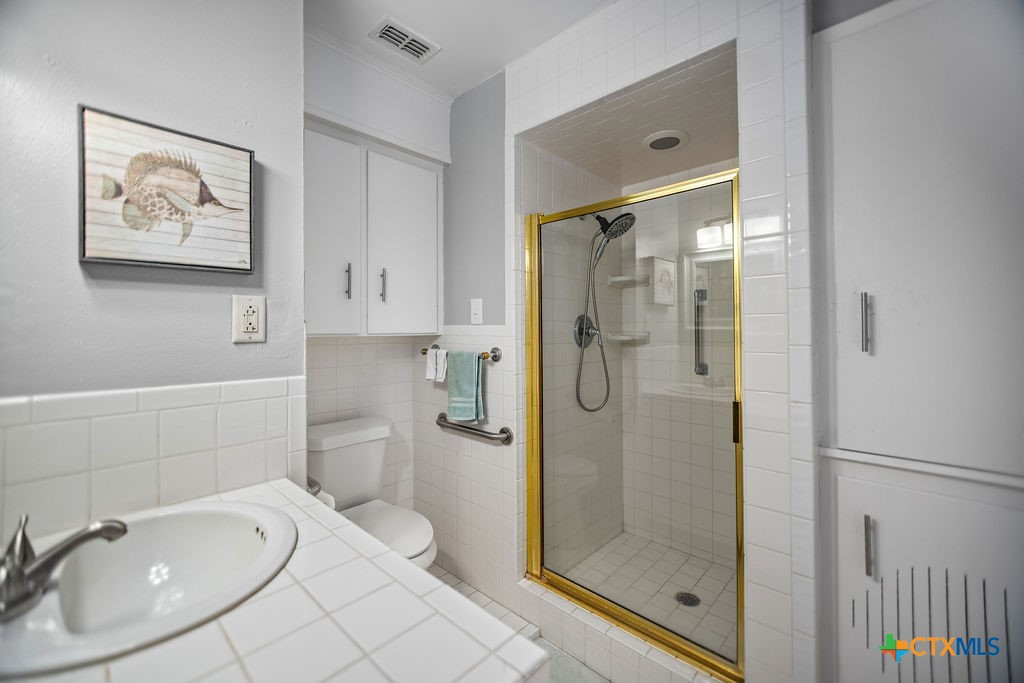 1315 Jackson Street Port Lavaca, TX 77979 - Photo 24 of 32 a bathroom with a shower sink and mirror