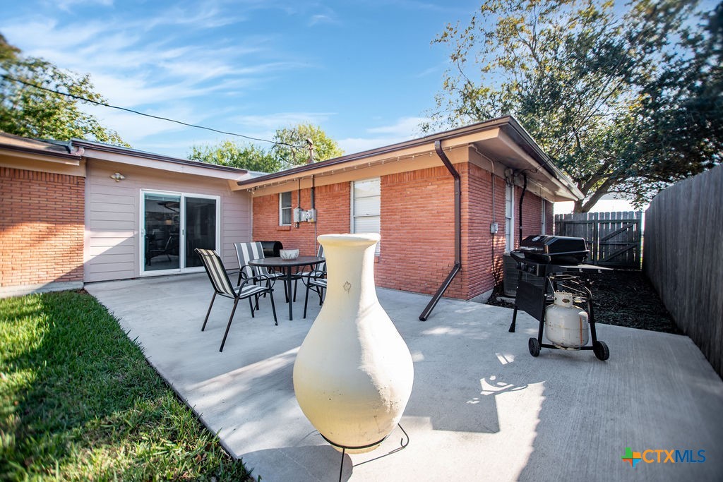 1315 Jackson Street Port Lavaca, TX 77979 - Photo 6 of 32 a view of a backyard with table and chairs potted plants and large tree