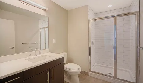 a bathroom with a sink a toilet and shower