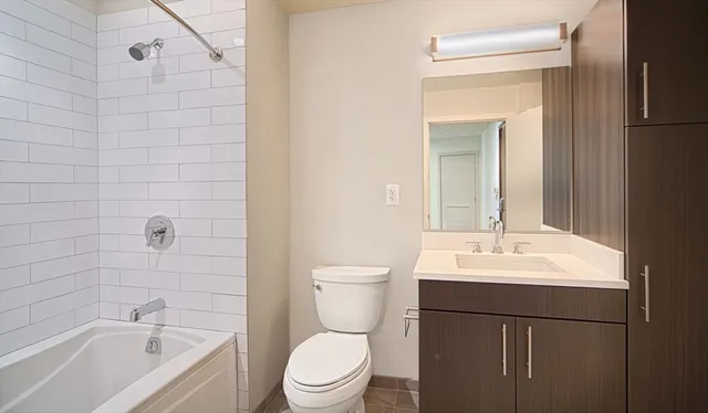 a bathroom with a toilet a sink a mirror and shower