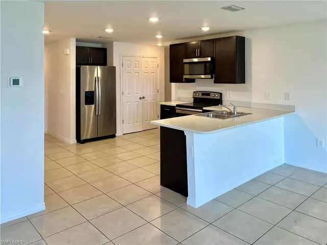 a kitchen with stainless steel appliances a refrigerator and a stove top oven