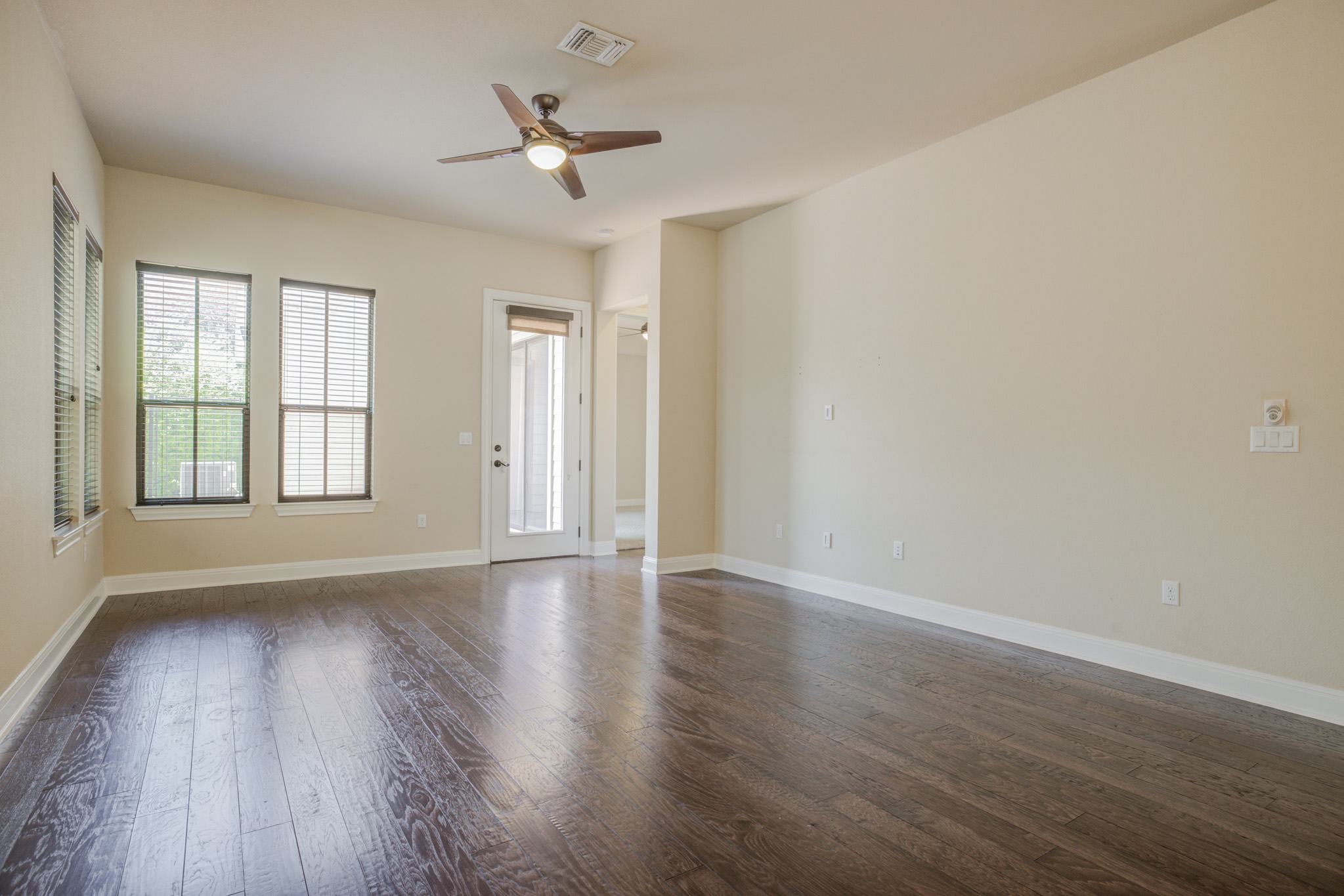4524 Berkman Drive Austin, TX 78723 - Photo 17 of 38 Spacious room featuring dark wood-finish flooring, light neutral-toned walls, and a vaulted ceiling