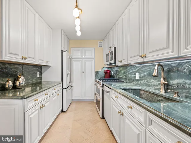 a kitchen with stainless steel appliances granite countertop a sink and cabinets
