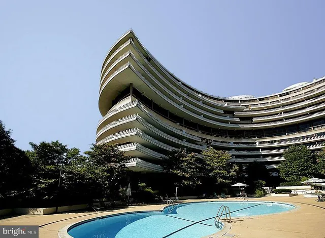 a view of a swimming pool with a yard and sitting area