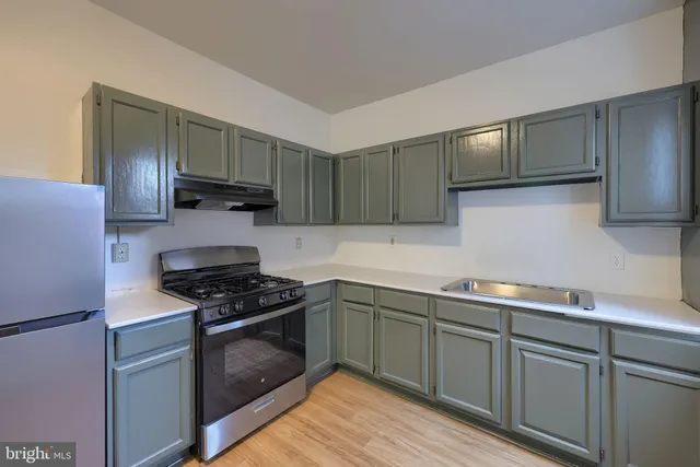 a kitchen with granite countertop a refrigerator stove top oven and sink