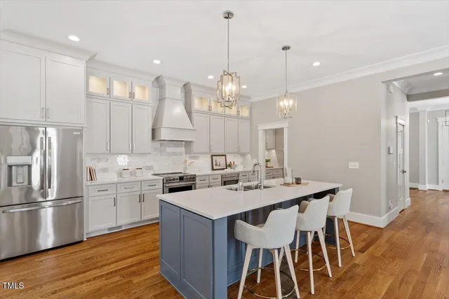 a kitchen with a sink appliances and wooden floor