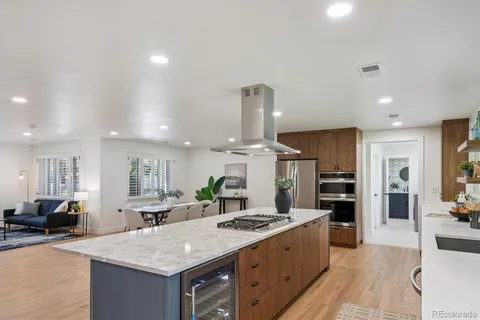 a large kitchen with kitchen island a stove a sink a refrigerator and a view of living room