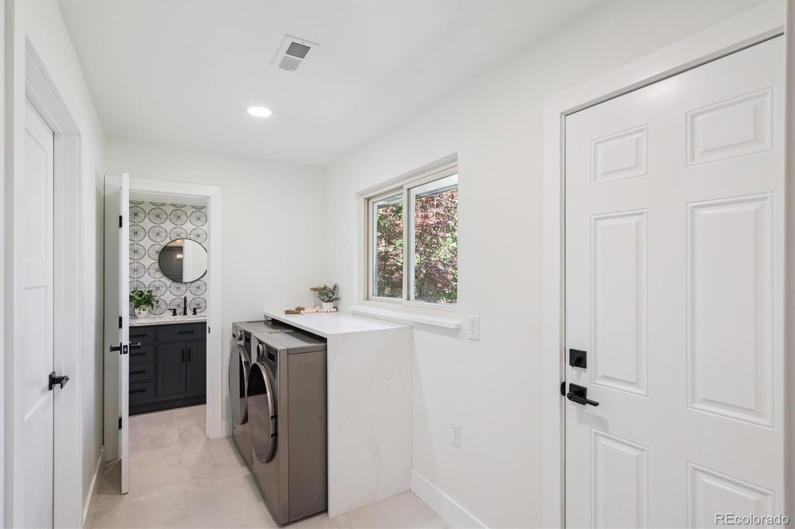 3775 South Forest Way Denver, CO 80237 - Photo 23 of 40 a utility room with cabinets washer and dryer