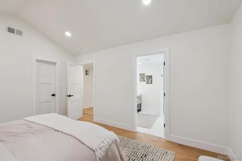a bedroom with a bed and wooden floor