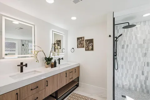 a bathroom with a double vanity sink mirror and shower