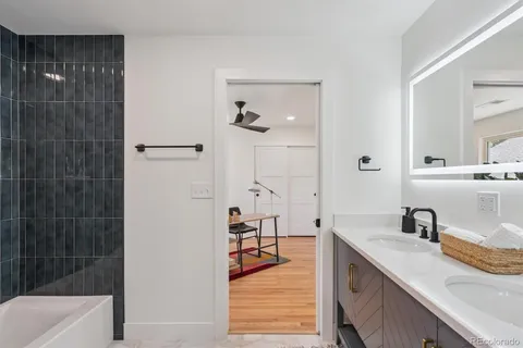 a bathroom with a tub sink and mirror