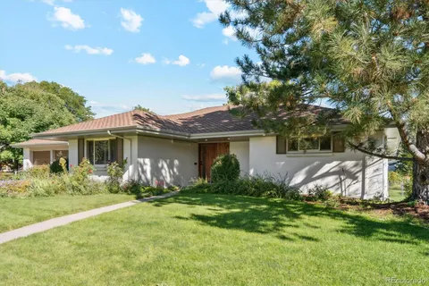 a front view of house with yard and trees around