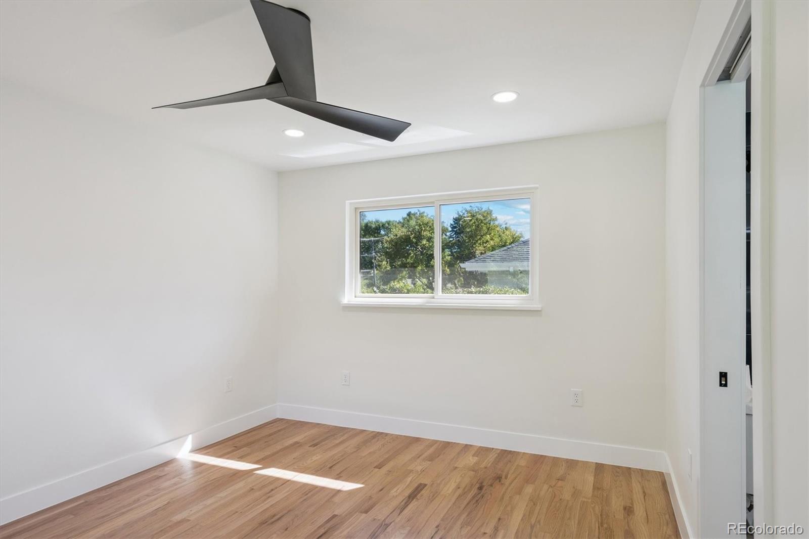 3775 South Forest Way Denver, CO 80237 - Photo 32 of 40 an empty room with wooden floor cabinet and windows