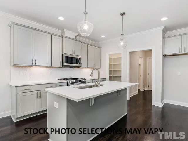 a kitchen with a sink stainless steel appliances and white cabinets