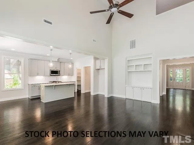 a view of a kitchen with kitchen island a stove a refrigerator counter top and a stove