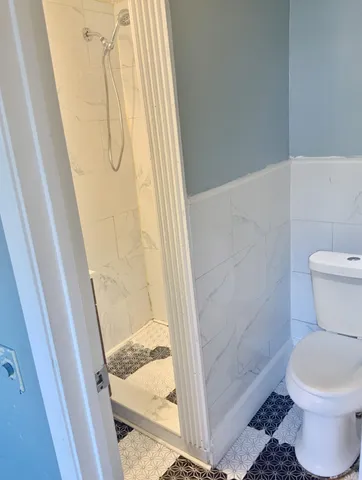 a bathroom with a toilet and shower