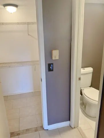 a white toilet sitting next to a shower