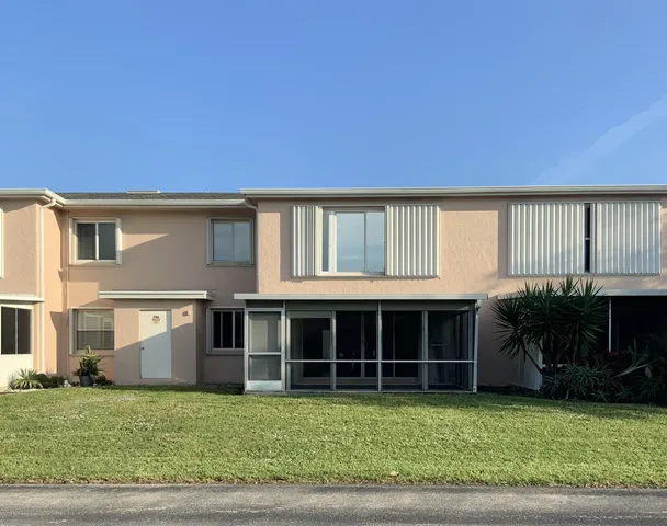 a view of a house with a yard and potted plants