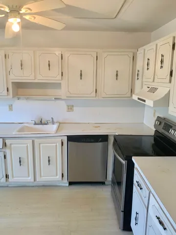 a kitchen with stainless steel appliances granite countertop a sink and a stove