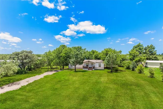 a view of a house with a yard and sitting area