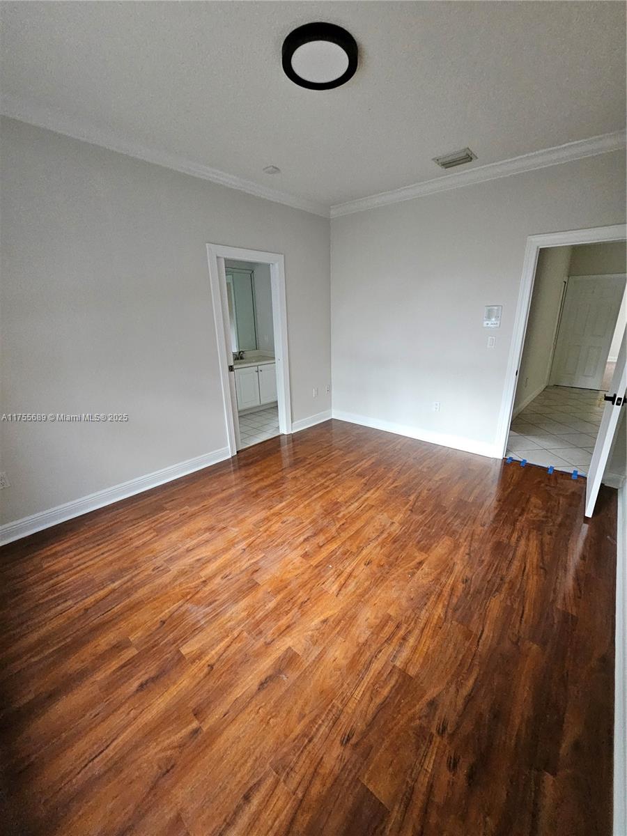 9491 Southwest 124th Terrace Miami, FL 33176 - Photo 14 of 26 an empty room with wooden floor and windows