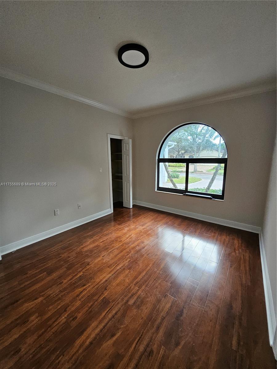 9491 Southwest 124th Terrace Miami, FL 33176 - Photo 16 of 26 an empty room with wooden floor and windows