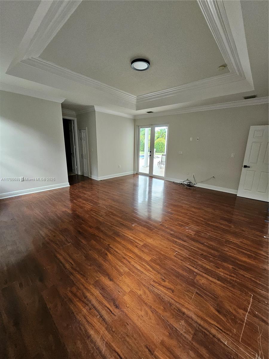 9491 Southwest 124th Terrace Miami, FL 33176 - Photo 21 of 26 an empty room with wooden floor and windows