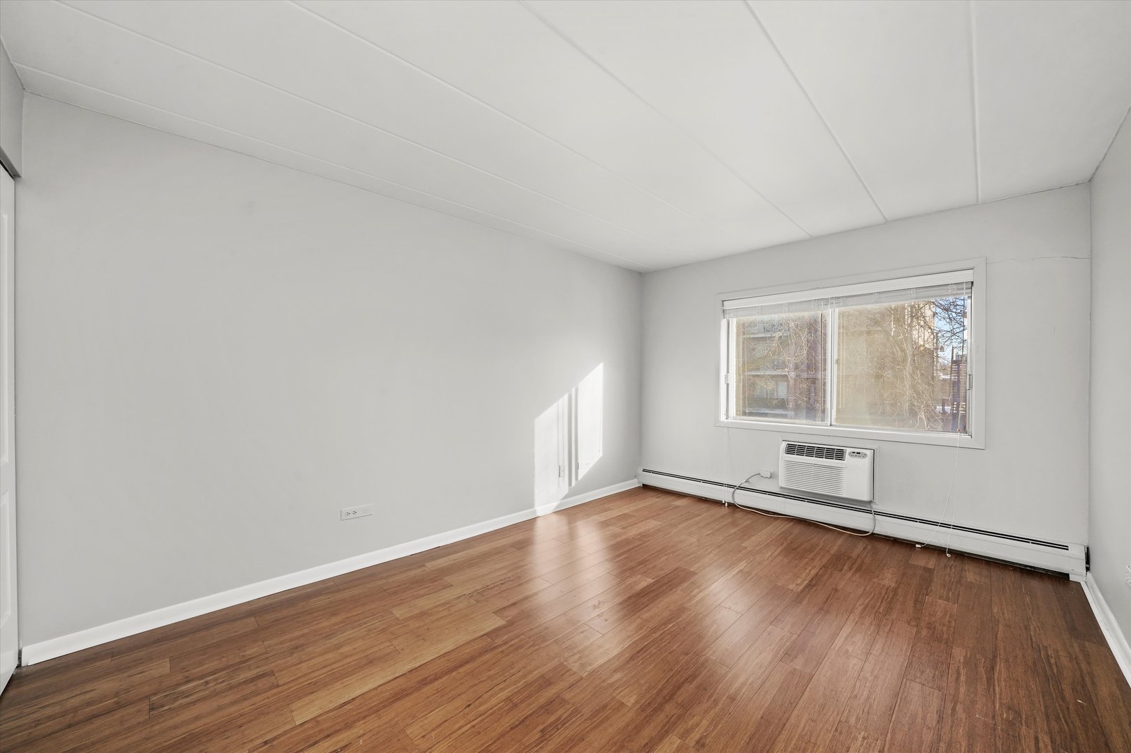 4240 North Keystone Avenue, Unit 2D Chicago, IL 60641 - Photo 11 of 18 an empty room with wooden floor and windows