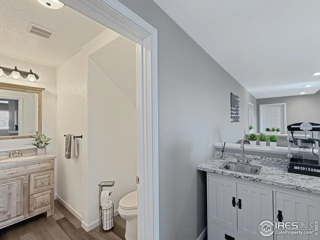 a bathroom with a granite countertop sink toilet and shower