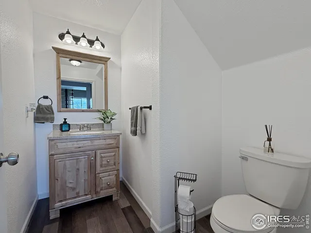a bathroom with a toilet a sink a vanity and mirror