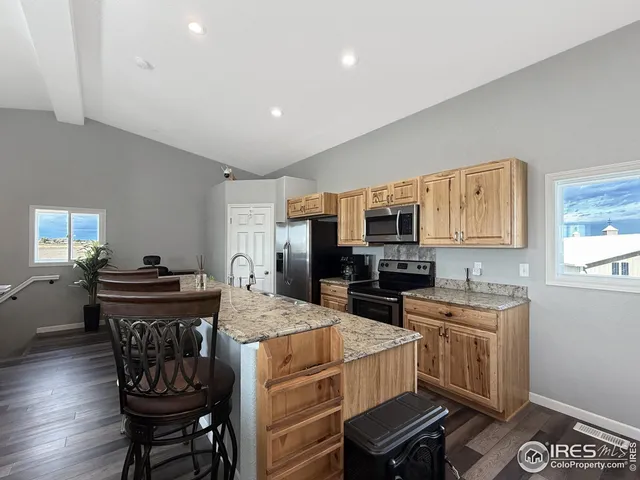 a kitchen with granite countertop a sink stove and refrigerator